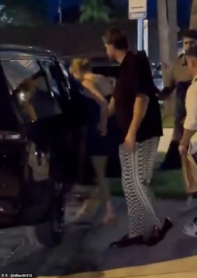 De mãos dadas com a estrela da NFL, Swift cumprimentou os fãs com um sorriso antes de entrar no banco do passageiro da frente de um SUV preto